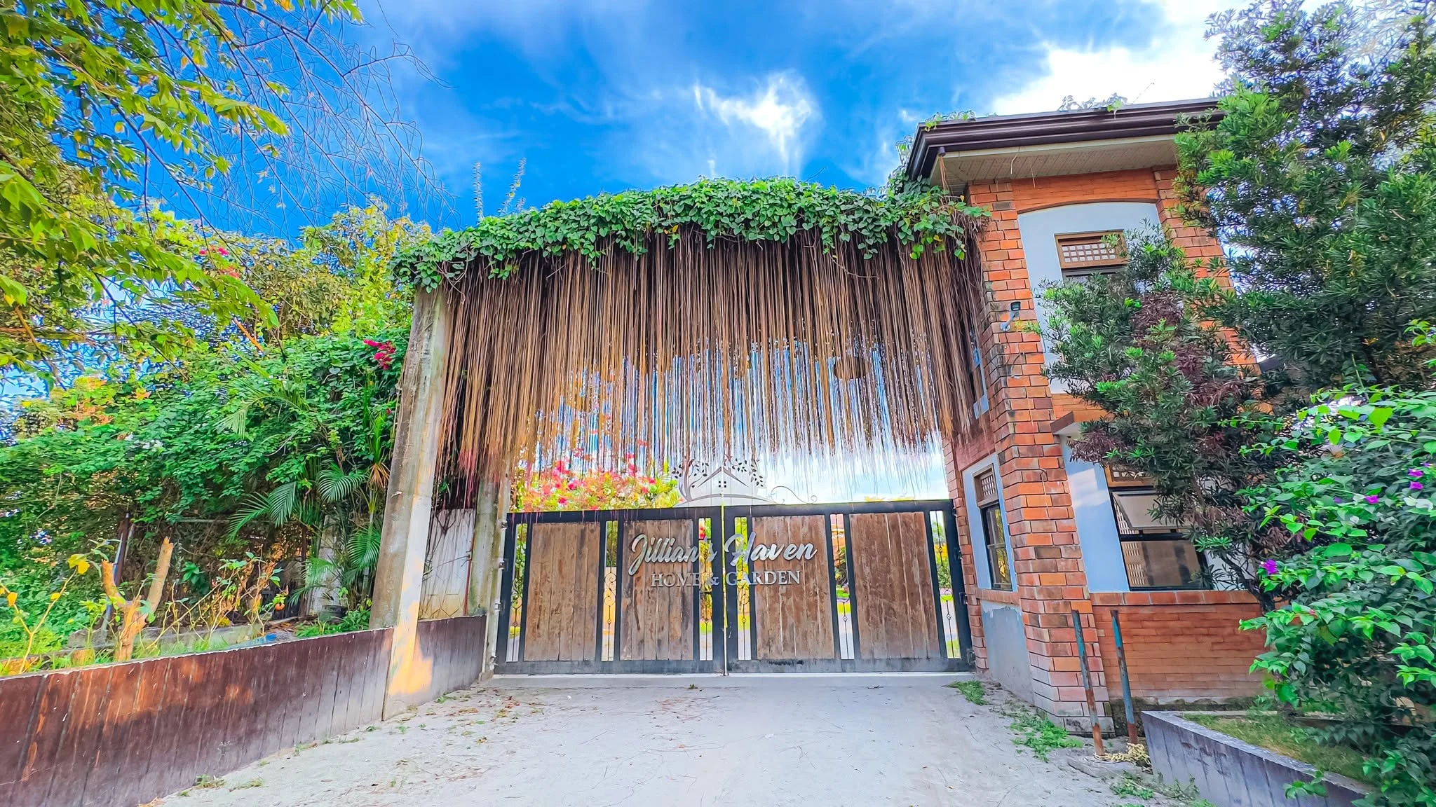 Entrance gate of Jillian’s Haven Home & Garden surrounded by green trees